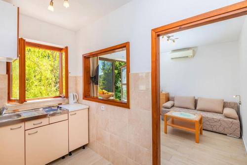 una cocina con fregadero y un sofá en una habitación en Family Apartment close to the Beach en Mlini