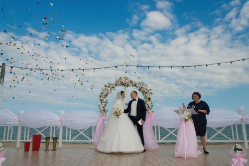 a bride and groom standing in front of a wedding arch at Shalanda in Odesa