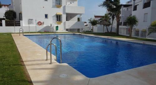 a large blue swimming pool in front of a building at Noctua Valle Romano Golf Estepona 003 in Estepona