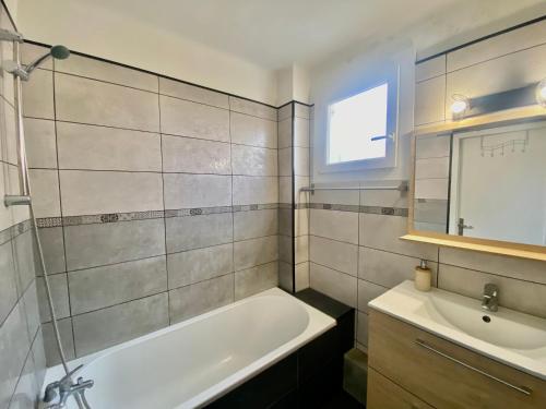 ein Badezimmer mit einer Badewanne und einem Waschbecken in der Unterkunft Superbe appartement 2 chambres, clim, quartier calme entre la mer et les calanques in Marseille