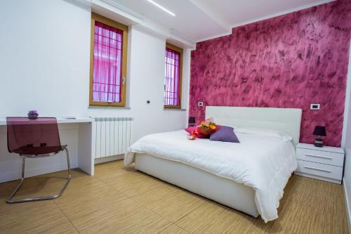 - une chambre avec un lit blanc et un mur rose dans l'établissement Valle Aurelia House, à Rome