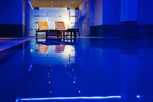 - deux chaises assises à côté de la piscine dans l'établissement Hotel Europe, à Ostende