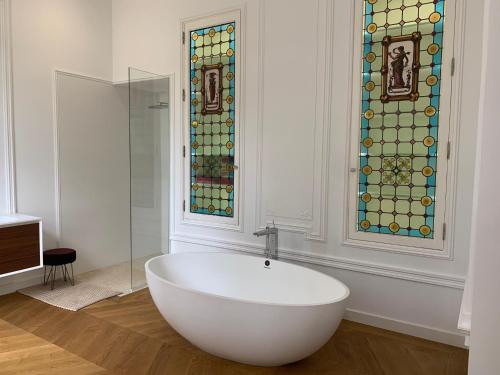 a bathroom with a bath tub and stained glass windows at Chambre d'hotes et Table d'hotes Domaine de la terrasse SAS et Gite ANDA Montauban in Lacourt-Saint-Pierre