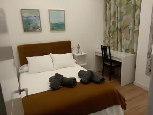 een slaapkamer met een bed met een bureau en een stoel bij Apartamento Roco in Madrid