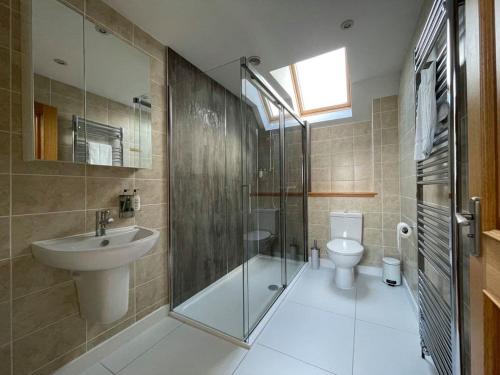 a bathroom with a shower and a sink and a toilet at Balloan Steading East in Dornoch