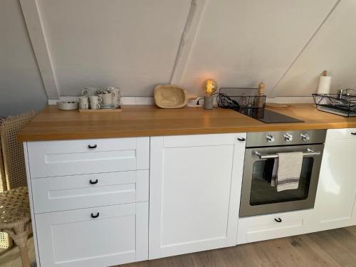 a kitchen with white cabinets and a stove at Streckhof Stiefelgasse 3 in Purbach am Neusiedlersee