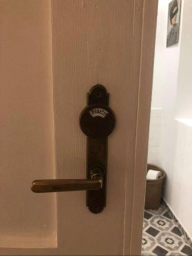 a bronze door handle on a door with a toilet at Streckhof Stiefelgasse 3 in Purbach am Neusiedlersee
