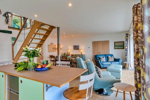 a kitchen and living room with a wooden table and chairs at Finest Retreats - Blue Seas in Mousehole
