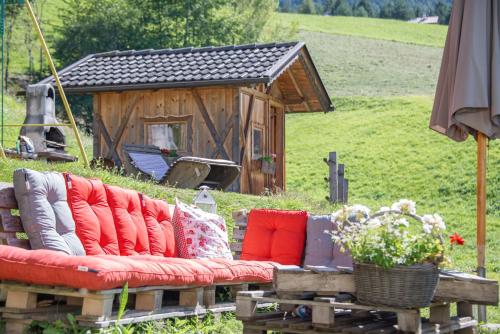 a couch with pillows sitting in front of a house at Gemangerhof in Bressanone