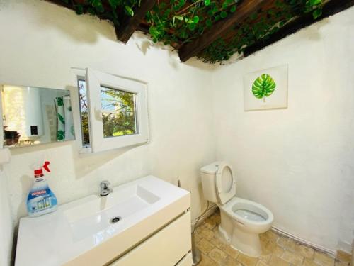 a white bathroom with a toilet and a sink at Simple Wooden house in Moçarria