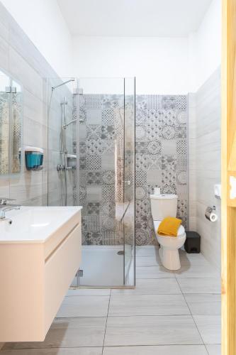a bathroom with a shower and a toilet and a sink at Villa Serenity B&B in Sannat