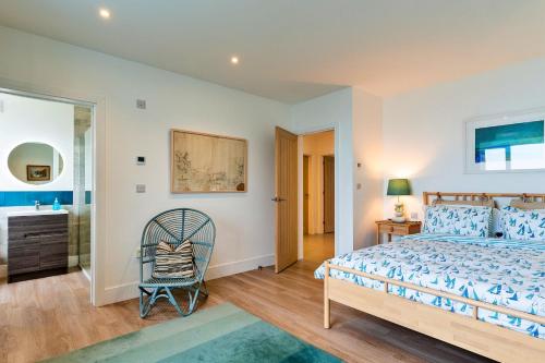 a bedroom with a bed and a chair at Finest Retreats - Blue Seas in Mousehole