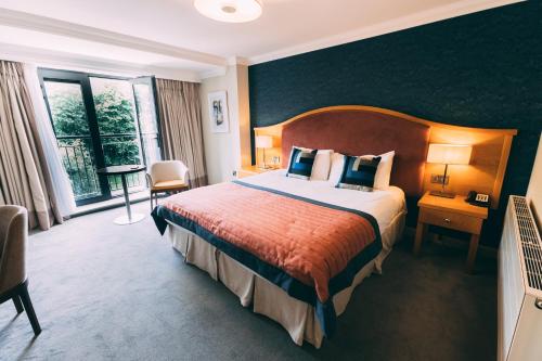 ein Hotelzimmer mit einem Bett und einem großen Fenster in der Unterkunft The Parkview Hotel in Newtown Mount Kennedy