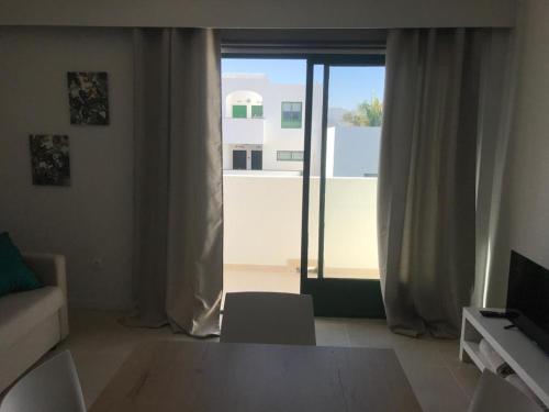 a living room with a couch and a large window at Casa Palmera in Costa de Antigua