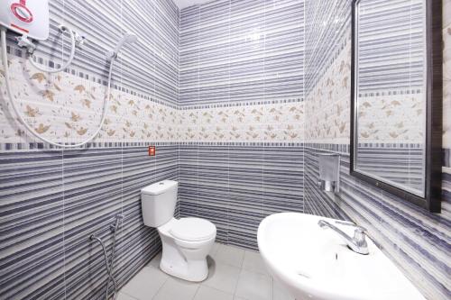 a bathroom with a toilet and a sink at Hotel Iskandar in Seri Iskandar