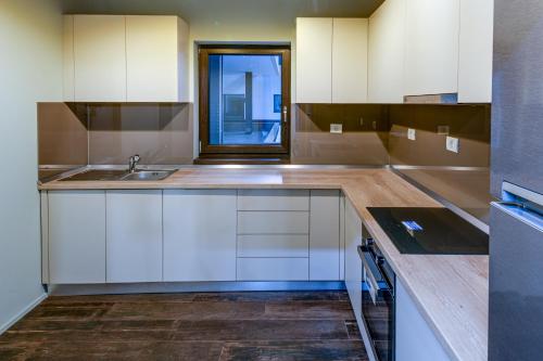 a kitchen with white cabinets and a sink at ArtHomes Apartments in Timişoara