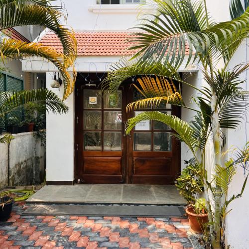 a wooden door of a house with a palm tree at Pepper Route, Fort Kochi in Fort Kochi