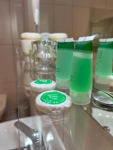 a glass counter with green glasses and a sink at Pałac Biedrusko in Poznań