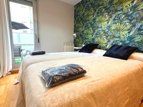1 dormitorio con 1 cama grande y papel pintado tropical en Dos Torres Mediodía - Amplia Terraza y Estacionamiento Gratuito, en Zaragoza