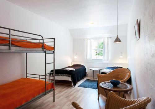 a room with two bunk beds and a table and chairs at Lille Grynborg in Blommenslyst