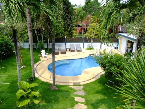 a swimming pool in a yard with palm trees at Let's Chill Pool Villa Pattaya Najomtien42 and Sattahip in Ban Tao Than