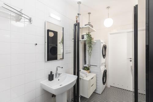 a white bathroom with a sink and a washing machine at SuperApart plac Konstytucji 6 in Warsaw