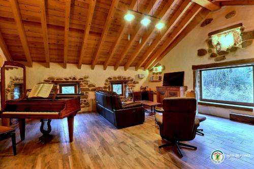 - un salon avec un piano et une chaise dans l'établissement Le Cocon du Vivarais, à Rochepaule