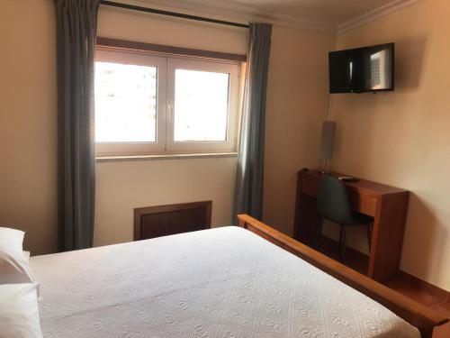 a bedroom with a bed and a window and a chair at casa largo do cruzeiro in Peso da Régua