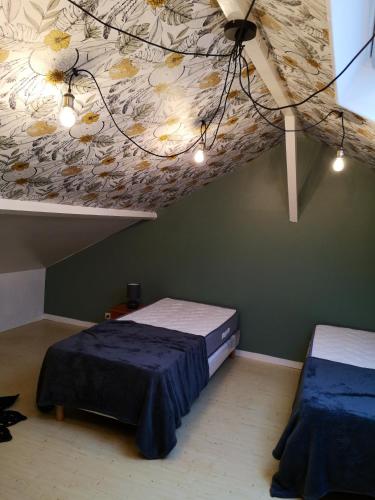 - une chambre avec deux lits et un plafond fleuri dans l'établissement Appartement cosy à Saint-Vaast-la-Hougue - 55 m² avec jardin, à Saint-Vaast-la-Hougue