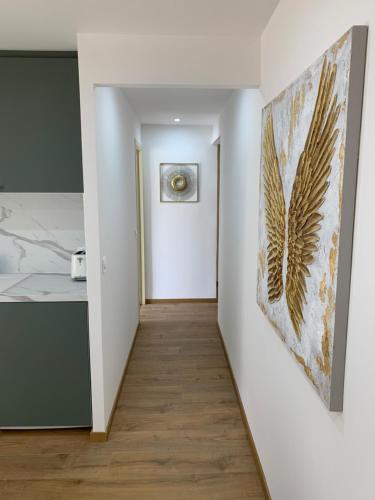 a hallway with white walls and a painting on the wall at APPARTEMENT OR in Manosque