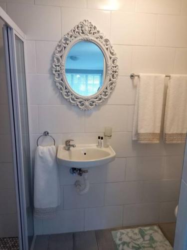 a bathroom with a sink and a mirror and towels at La Damon 1 in Paarl