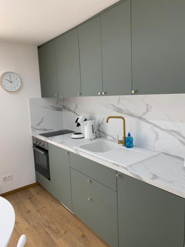 a kitchen with white marble counter tops and a sink at APPARTEMENT OR in Manosque