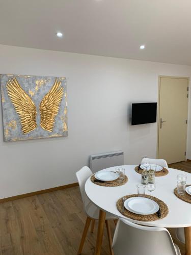 a dining room with a white table and chairs at APPARTEMENT OR in Manosque