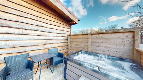 a hot tub on a deck with a table and chairs at Barker Stakes Farm in Pickering