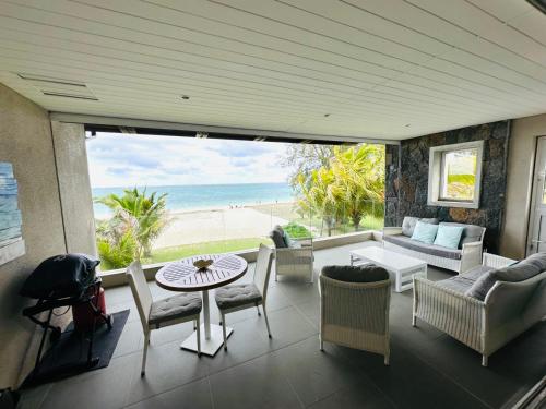 een woonkamer met uitzicht op het strand bij Pointe d'Esny Beachfront Luxury Apartment in Pointe d'Esny