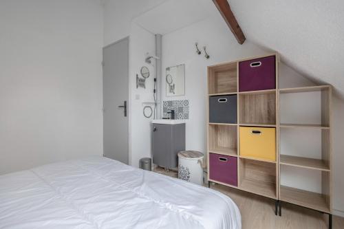 ein Schlafzimmer mit einem Bett und einem Bücherregal in der Unterkunft Vacances à Saint Gildas de Rhuys pour 4 in Saint-Gildas-de-Rhuys