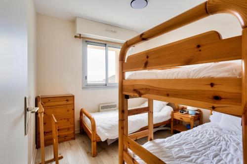 埃爾基的住宿－Appartement a moins de 100m de la plage du Bourg pour 4 personnes，一间卧室设有两张双层床和一扇窗户。