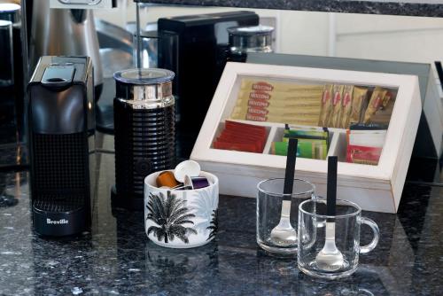 a counter with two glasses and a box of toothbrushes at Sandon Point Coastal Abode in Bulli
