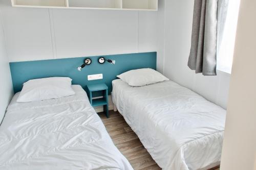 two beds sitting next to each other in a room at Joli Chalet a Bretignolles sur mer pour 6 personnes in Brétignolles-sur-Mer