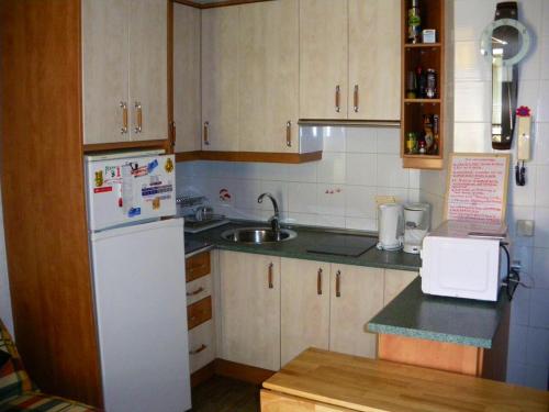 a kitchen with a white refrigerator and a sink at Modern apartment in Torrevieja with terrace – 58 m² in Torrevieja