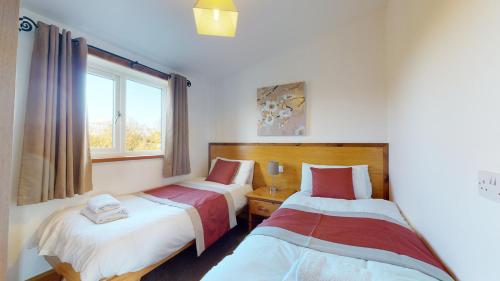 a bedroom with two beds and a window at Barker Stakes Farm in Pickering