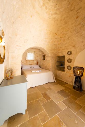 a bedroom with a bed in a stone room at Esclusive luxury private trulli in Martina Franca