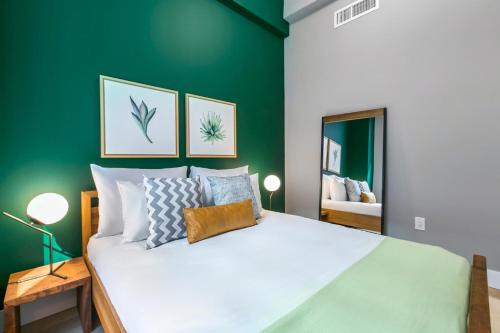 a bedroom with a large white bed with a green wall at Tribeca 1BR w Gym Doorman Rooftop garden NYC-52 in New York