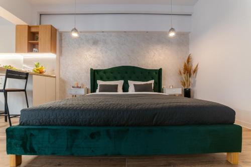 um quarto com uma grande cama verde e 2 almofadas em SummerTime Tomis Villa Studio Mamaia Nord em Năvodari