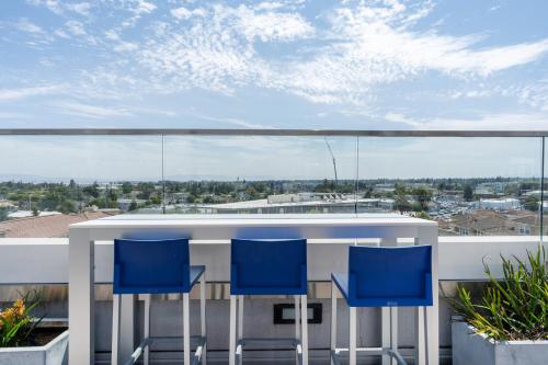 a balcony with a white table and blue chairs at Redwood City 2BR w AC Gym WD nr Caltrain SFO-1110 in Redwood City