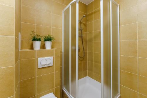 a bathroom with a shower with a toilet and plants at CHILLIapartamenty- Kasprowicza - JAZZ in Kołobrzeg