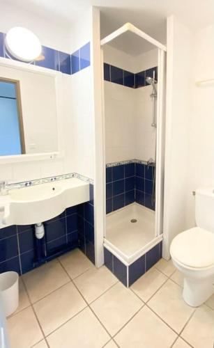 une salle de bain avec toilettes et lavabo dans l'établissement Joli appartement tout confort près de la plage, à Fouesnant