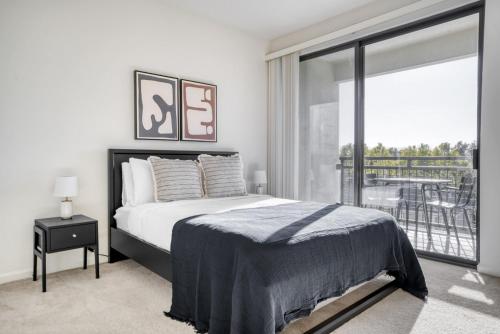 a white bedroom with a bed and a large window at San Jose 1br w wd gym pool nr Caltrain SFO-1154 in San Jose
