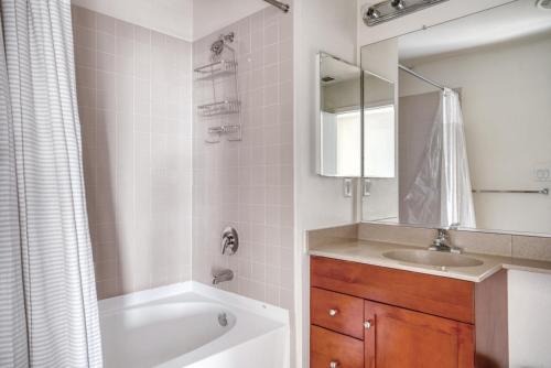a bathroom with a tub and a sink and a mirror at San Jose 1br w wd gym pool nr Caltrain SFO-1154 in San Jose