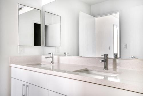 a white bathroom with two sinks and two mirrors at Palo Alto 1br w gym pool wd nr Stanford SFO-1259 in Palo Alto